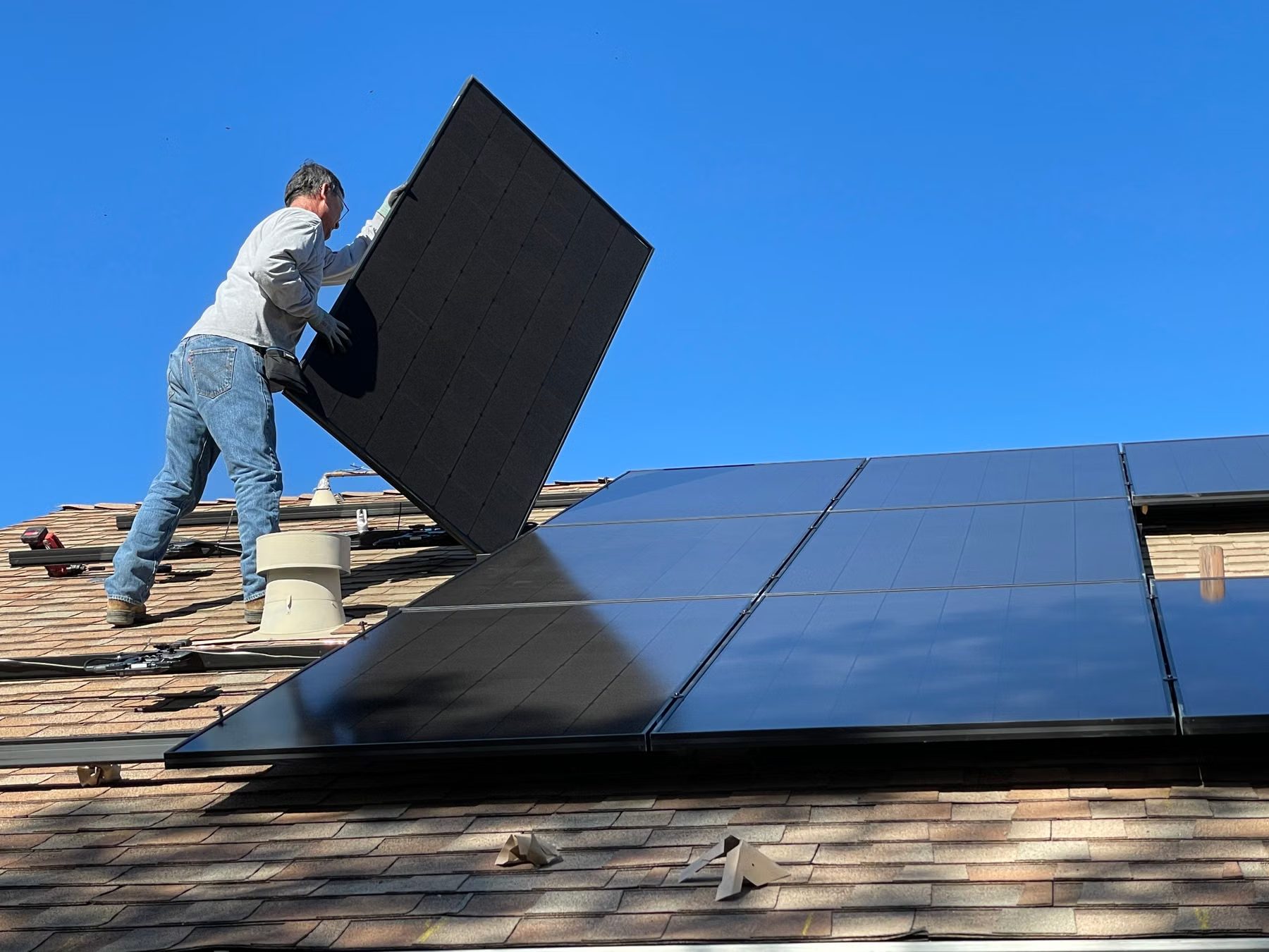 Technician installing solar panels on a rooftop